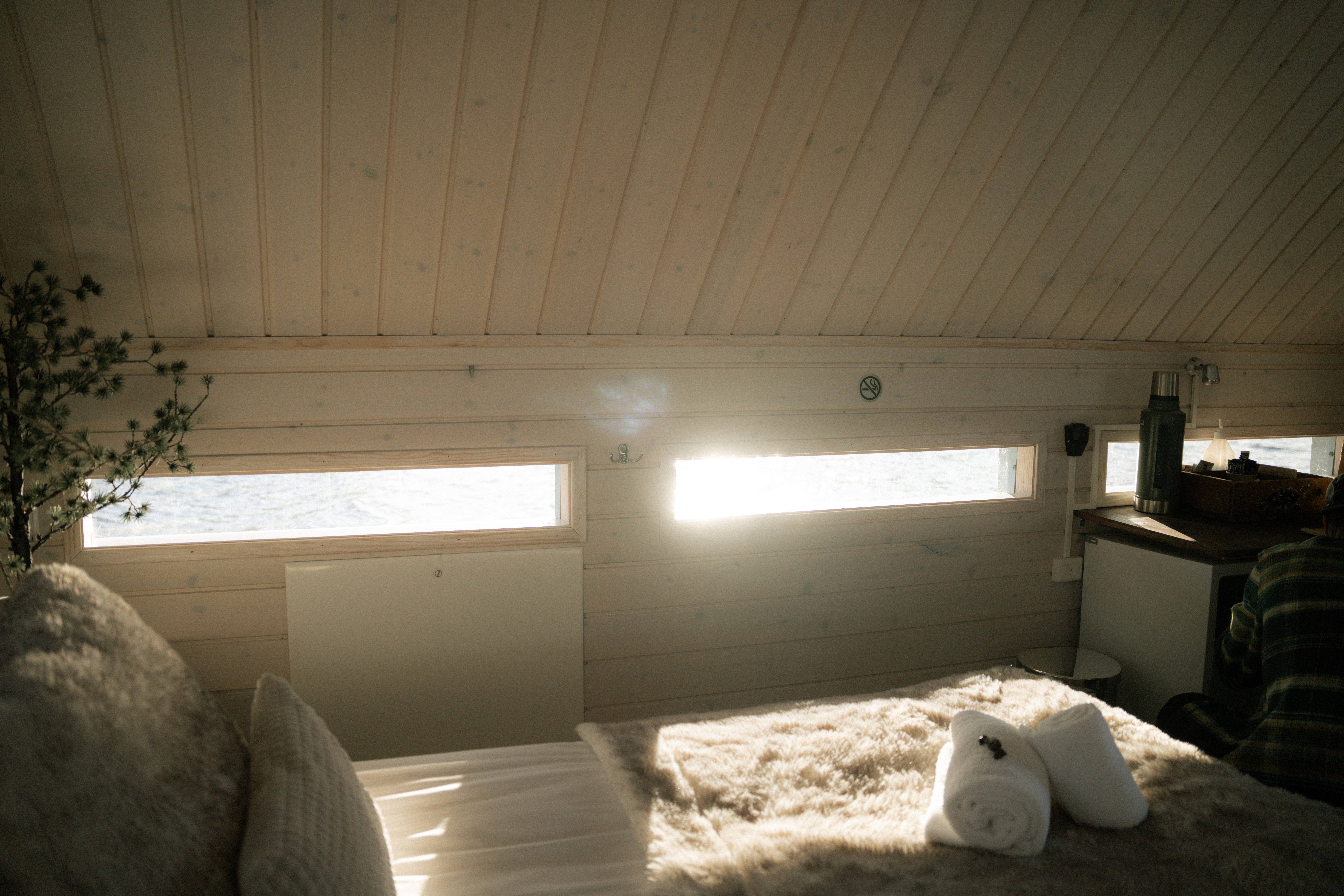 Morgonsol genom fönstren över sängen i det flytande hotellrummet